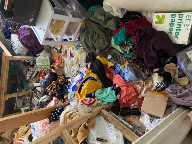 Image shows a room filled with trash and clutter. Bio-One of Orange helped clear out place so the individuals could return home safe.