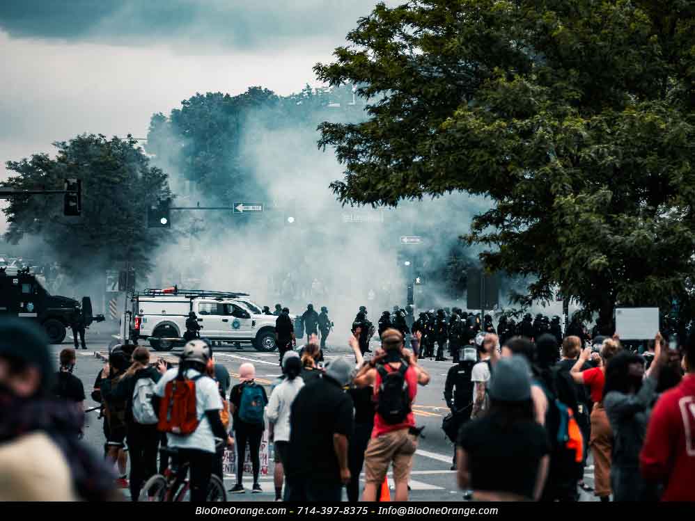 Riot protest, tear gas in environment. Photo credit: Colin Lloyd/Unsplash. Bio-One of Orange.